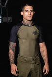 Male model wearing an olive green and black BJJLIFESTYLE Jiu-Jitsu rashguard, front view.