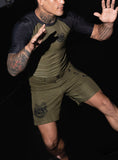 BJJ athlete demonstrating a grappling stance in the olive green Bone Breaking rashguard and fight shorts by BJJLIFESTYLE.