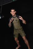 BJJ athlete in a grappling stance wearing the olive green Bone Breaking rashguard and matching fight shorts by BJJLIFESTYLE.